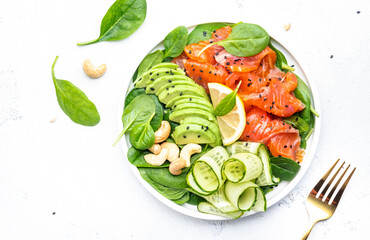 Keto salad with salmon, avocado, spinach, cucumber, sesame seeds  and cashew nuts. Low-carbohydrate...