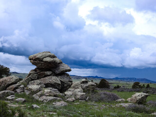 Fototapeta na wymiar Big Rocks on a Mountain with Storm Clouds and Rain in the Background