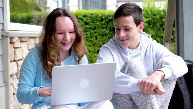 sincere loud laughter boys girl watching movie internet online laughing out loud turning away shy teenagers sitting on the porch discuss mocking flirting friends communication modesty girl