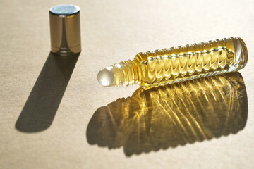 Oil roller perfume on a beige background.