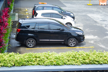high angle view of suv and hatchback cars in the parking lot of a mall with green grass in...