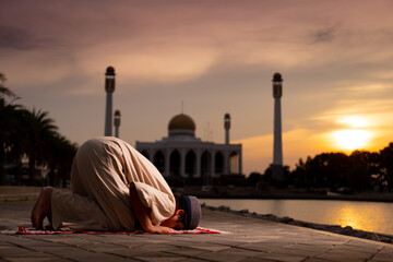 A little Asian Muslim boy is praying with peace in the beautiful mosque, giving a powerful...