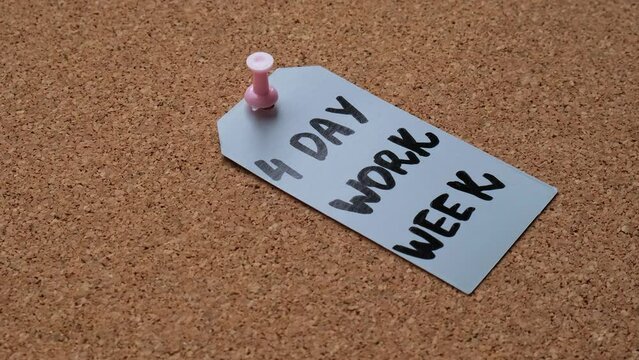 Hand pin note 4 day work week text on paper note pinned to desk four day working week concept. Modern approach doing business short workweek. Effectiveness of employees. Productivity and efficiency