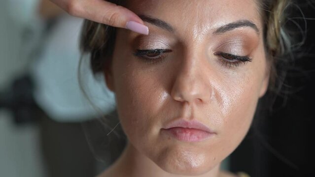 Makeup Artist Outlining the Eyes and Eyelashes of Bride