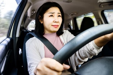 new Asian driver scared to drive feeling fear and not confident sitting in a car with a worried face - obrazy, fototapety, plakaty