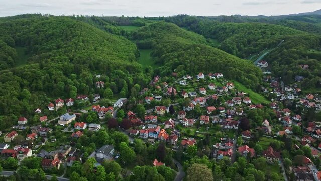 Drone shot of Wernigerode town on the Harz mountains , Saxony-Anhalt, Germany . A stunning view of a town located on a green mountain .