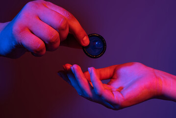 Closeup of couple giving condom. Condom in male hand and female hand, give condom safe sex concept....