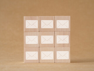 Envelope icon symbol on wooden cube over brown background. Concept sends an e-mail or newsletter. Business technology...