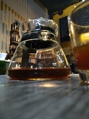 Manual brewing coffee pour over in my coffee shop and now closed. with some good light and beautiful shadow frame plant on wood table