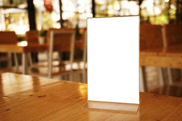 Mock up Menu frame standing on wood table in Bar restaurant cafe. space for text