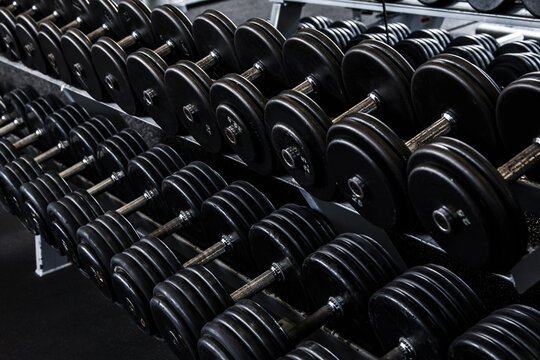 Different black dumbbells in the modern gym