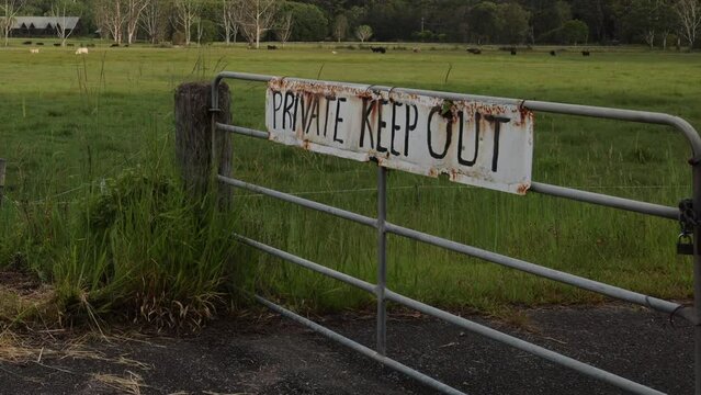 Keep Out Sign at Farm Fence in Rural Landscape