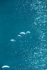 Small air bubbles in blue water, background.