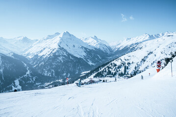 Fototapeta na wymiar Skiers skiing on snow covered mountain slope against blue sky