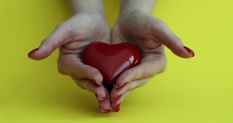 Volunteer holding red heart in hands. Woman promoting charity donation campaign or health insurance