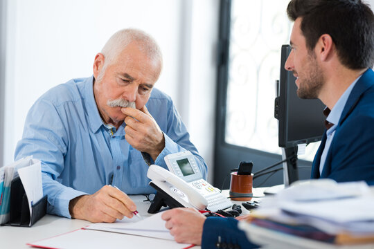 senior and young employees in office