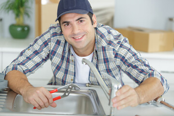 plumber man fixing kitchen sink