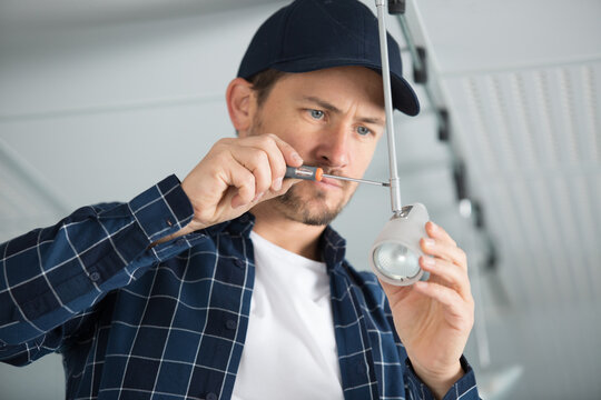male worker screws a light