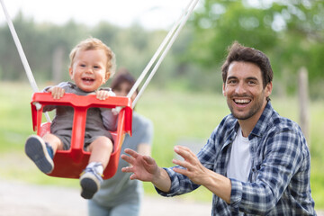 parents and child playing on outdoor playground