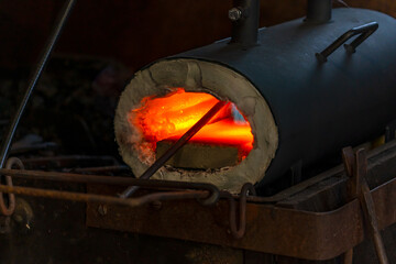 An iron piece is heated in a forging furnace.
