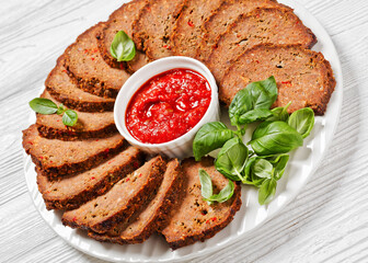 italian meatloaf cut in slices on white plate