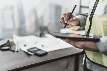 Architect, Engineering working with house drawings inspection on tablet in the office. Engineer, Architect, Industry and factory concept.
