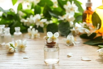 Obraz na płótnie Canvas Jasmine essential oil (tincture, remedy, infusion) bottle with fresh jasmine flowers. Flower essential oil. Herbal medicine. Side view, copy space.