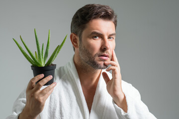 Beauty man hold aloe vera. Hispanic man with aloe vera green leaf near face. Clean face, face care,...