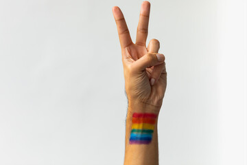 Close up of hand of biracial man with peace sign with rainbow flag on white background, copy space