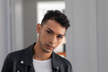 Portrait of biracial transgender man wearing biker jacket, looking at camera