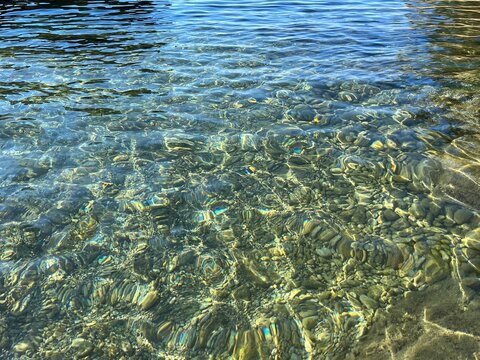 Sea water with smooth pebbles stones at the seabed.