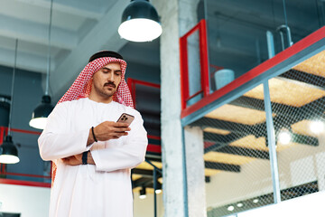 Young Arab businessman using smartphone in the office