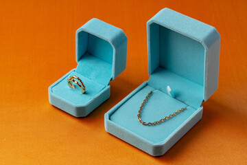 Blue boxes with golden jewelry on orange background