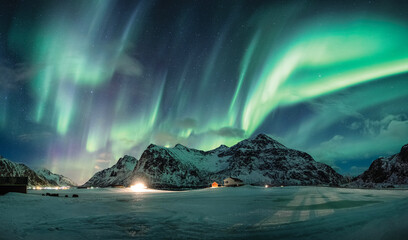 Fototapeta na wymiar Aurora borealis or Northern lights over snow mountain on coastline