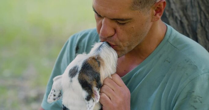 Love and communication with pets as a way to mental health. A middle-aged man with his Jack Russell Terrier dog. Close-up view. Slow motion 4k footage.