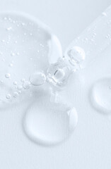 Dropper pipette with trasparent liquid on product smear with bubbles. Cosmetic,medicine, labaratory...