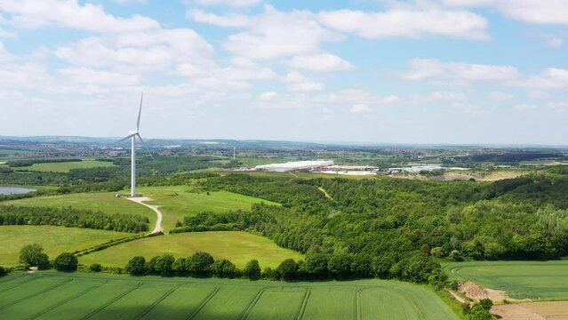 Aerial drone footage of the village of Great Houghton in the Metropolitan Borough of Barnsley in South Yorkshire, England showing the wind turbines in the beautiful village on a sunny summers day.