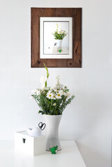 flowers in a vase and a framed picture of flowers in a vase