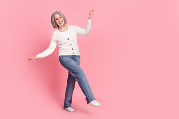 Full body photo of excited positive aged person dancing clubbing empty space isolated on pink color background