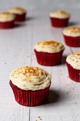 red velvet cupcake with icing and gold sprinkles