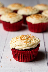 red velvet cupcake with icing and gold sprinkles