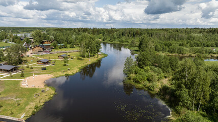 panoramic view of the river and coastal forest and houses on a summer day shot from a drone