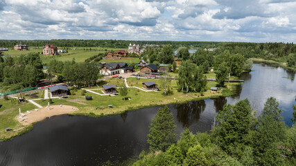 panoramic view of the river and coastal forest and houses on a summer day shot from a drone