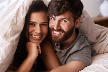 Obraz premium Bed blanket, face and portrait of happy couple, relax and enjoy morning together bonding on Croatia vacation holiday. Happiness, smile and romantic woman, man or people resting in home bedroom