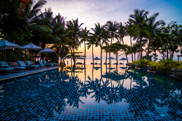 Obraz premium Beachfront sunrise with pool and palm trees in Hua Hin, Prachuap Khiri Khan, Thailand