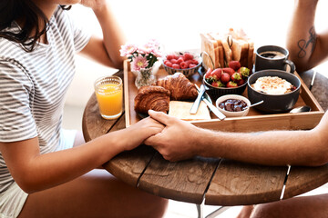 Restaurant food, breakfast or couple holding hands for support care, security or love on Valentines Day date. Cafe meal, marriage bond and brunch tray of croissant, strawberry or bread in coffee shop - obrazy, fototapety, plakaty