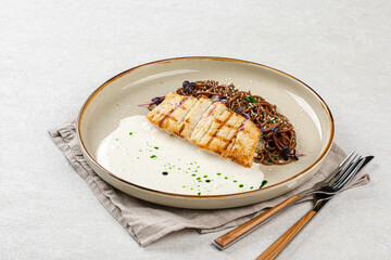 Portion of halibut fillet with soba noodles and creamy sauce