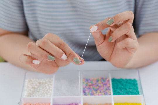 Woman stringing beads as a hobby