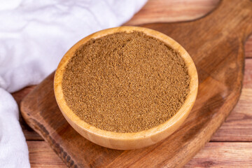 Coriander powder on wooden background. Powdered dried Coriander in wooden bowl
