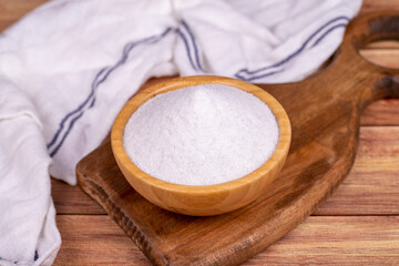 Natural minaret crystal non-iodized grinding salt on wooden background. Ground rock salt in wooden bowl